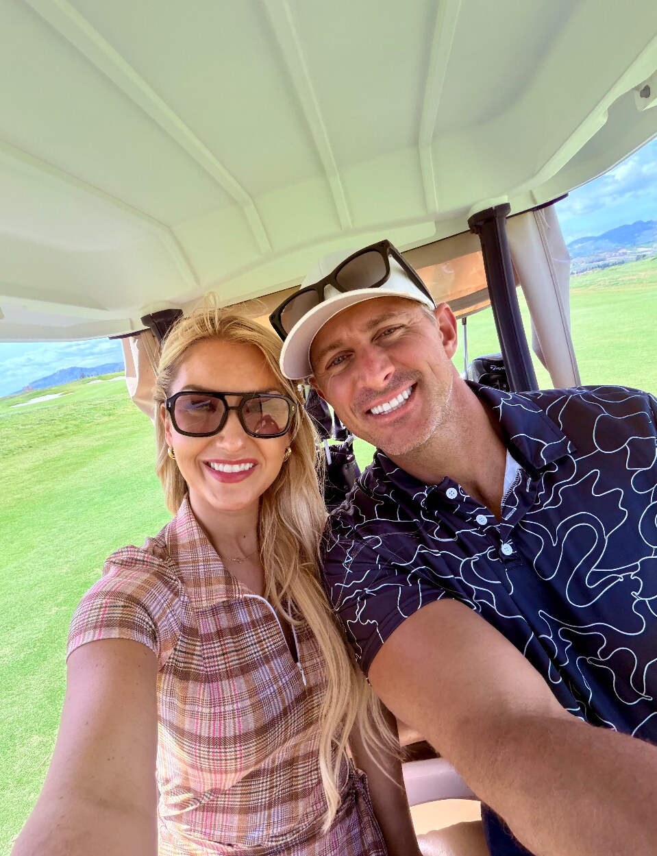 Summer and Devin smiling together from a golf cart